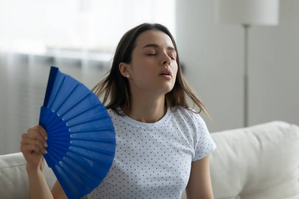 istock Overheated young woman wave with hand fan 1290577497