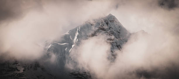 istock Snowcapped Nepalese Himalayan Mountain Peak with Moody Clouds 1290577924