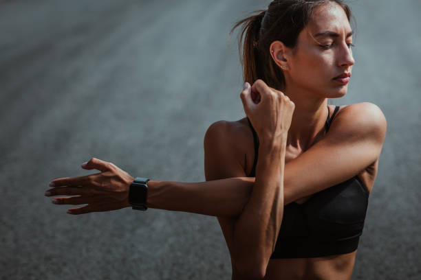 Female stretching after jogging while sitting on the road