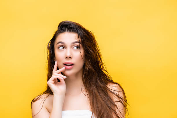 dreamy beautiful woman with wet hair isolated on yellow dreamy beautiful woman with wet hair isolated on yellow wet hair stock pictures, royalty-free photos & images