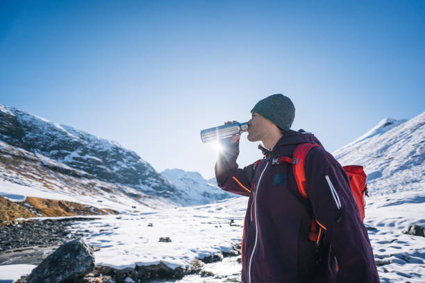 istock Backcountry skier drinks from waterbottle in snowy valley 1290580284