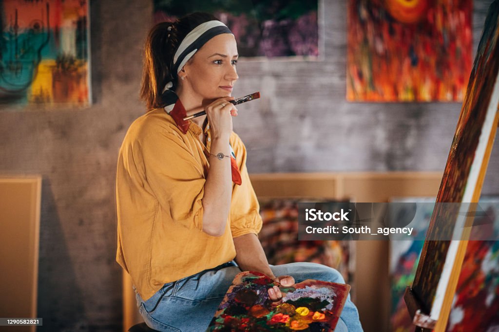 A női művész nézi a festményét, és inspirációt próbál találni - Jogdíjmentes Alkotókészség témájú stock fotó A női művész nézi a festményét, és inspirációt próbál találni - Jogdíjmentes Alkotókészség témájú stock fotó
