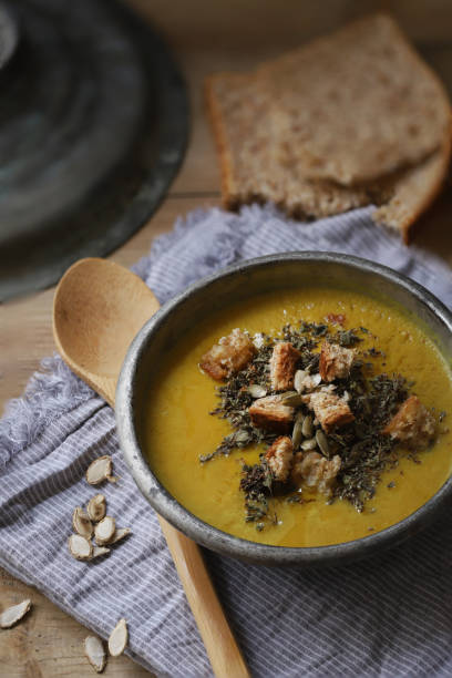 istock Pumpkin Soup Wooden Spoon and Grey Tea Towel 1290583041