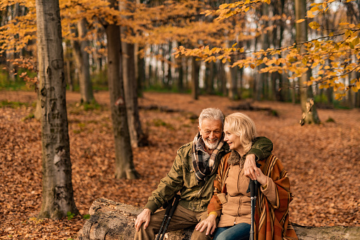 Happy senior couple taking a break from hiking and embracing.