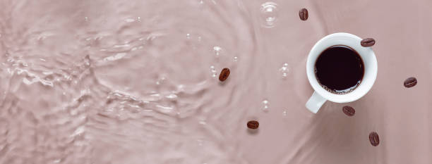 Hot coffee is splashing in cup. water and beans are blending