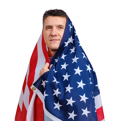 Handsome middle-aged man covered with American flag and looking at camera isolated on white background.