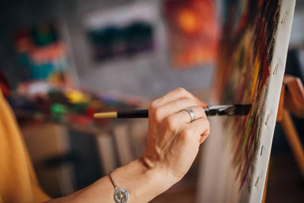 istock Female artist's hand painting in art studio 1290584147