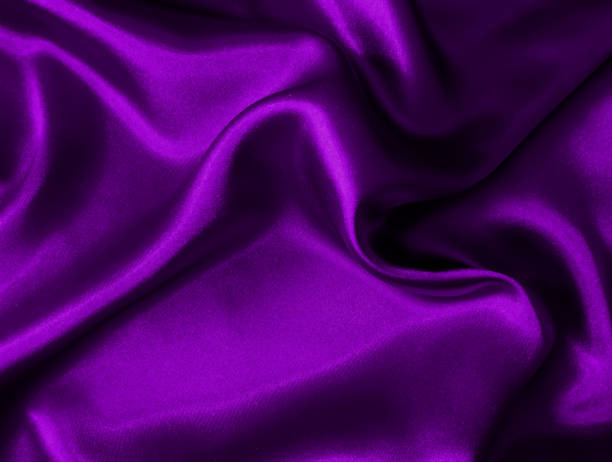 istock Shiny purple crumpled fabric texture. Elegant wavy cloth background 1290590729