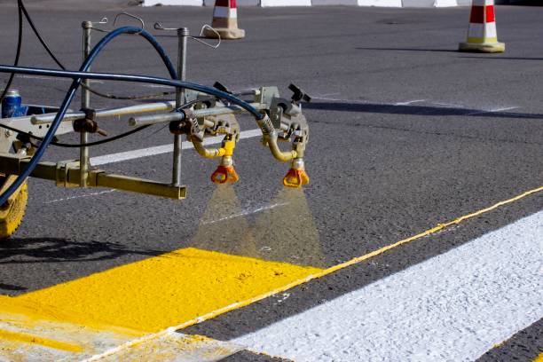 istock a team of workers drawing a pedestrian crossing in early spring using automated equipment on fresh asphalt 1290590756