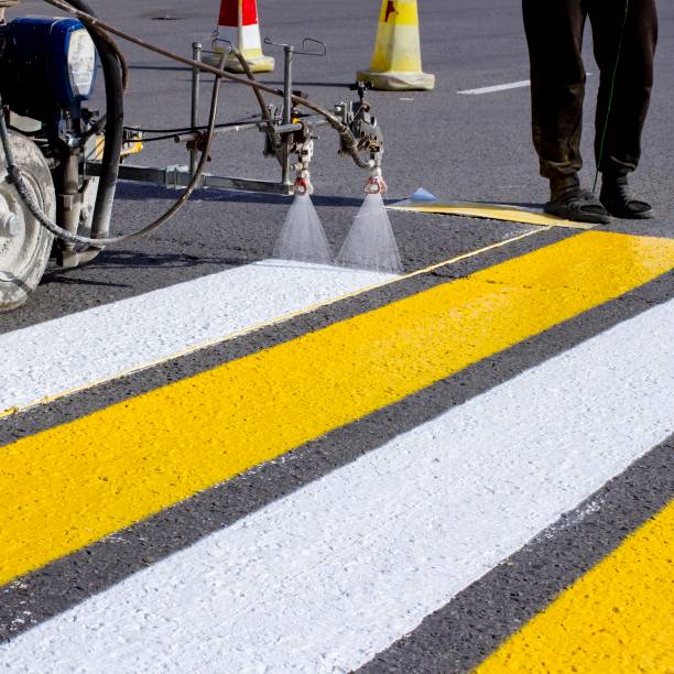 istock a team of workers drawing a pedestrian crossing in early spring using automated equipment on fresh asphalt 1290590761