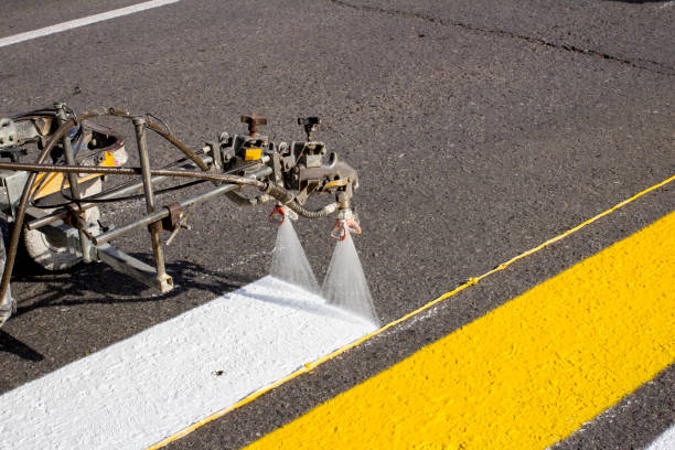 istock a team of workers drawing a pedestrian crossing in early spring using automated equipment on fresh asphalt 1290590769