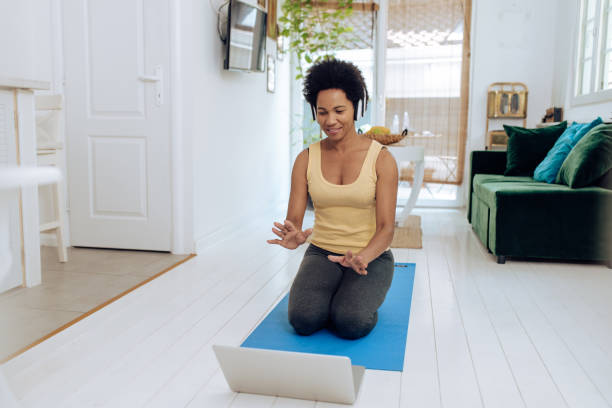 istock African-American yoga teacher having an online class with her clients 1290595582