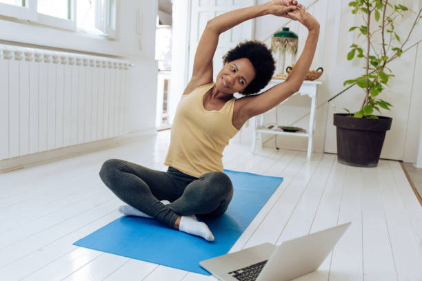 istock African-American doing online yoga at home 1290596175