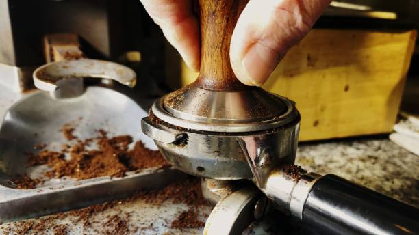 istock Barista Tamping Ground Coffee to make Espresso 1290598066