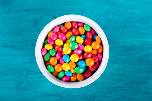 istock Colorful Confetti candy in bowl with blue background. 1290598115