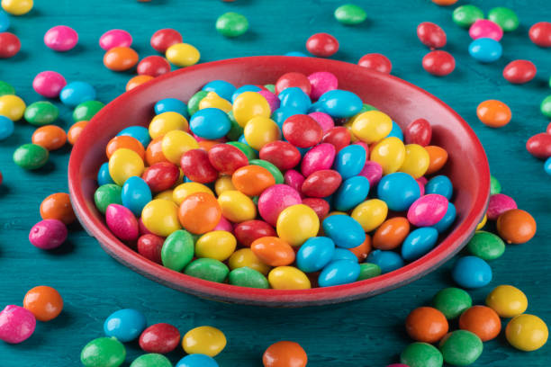 istock Colorful Confetti candy in bowl with blue background. 1290598117
