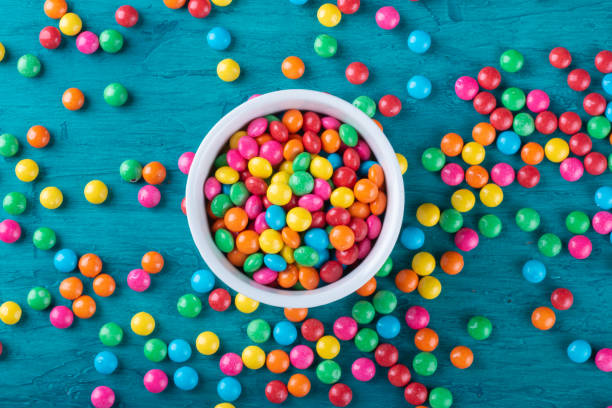 istock Colorful Confetti candy in bowl with blue background. 1290598126
