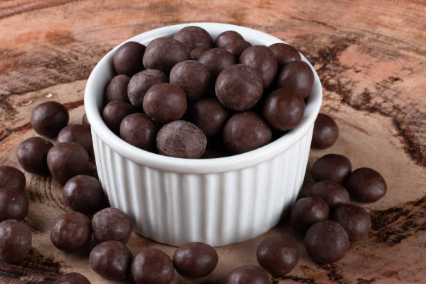 istock Chocolate balls in white bowl on wooden background. 1290598301