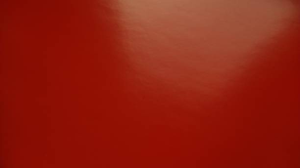 Beautiful bright red background. Closeup sheet of shiny reflecting incident light paper. Pure fun color. Intense shade of red, close to brown, bordeaux or blood color with high reflectivity Beautiful bright red background. Closeup sheet of shiny reflecting incident light paper. Pure fun color. Intense shade of red, close to brown, bordeaux or blood color with high reflectivity. reflectivity stock pictures, royalty-free photos & images