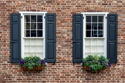 Vintage open window wood shutter on a white wall of a rustic home