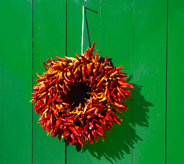 santa fe stil: weihnachten chili pfeffer ristra kranz, grüne tür - wreath chili pepper pepper ristra stock-fotos und bilder
