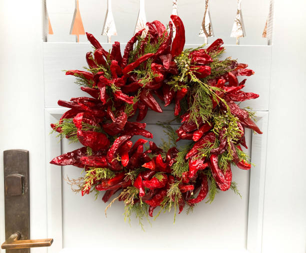 santa fe stil: weihnachten chili pfeffer ristra kranz, weiße tür - wreath chili pepper pepper ristra stock-fotos und bilder