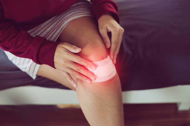istock Women using white patch for relieve wound on knee,Elastic bandaged,Gauze pad 1290613833