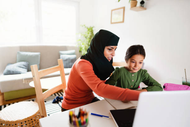 istock Muslim mother helping her child with online education 1290614075