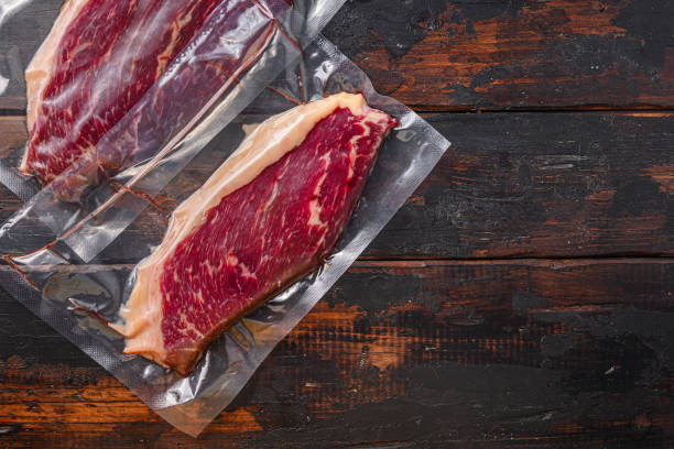 istock Picanha beef steak for sous vide cooking on dark old wooden table, top view space for text. 1290614923
