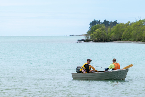 Canterbury New Zealand - November 20 2020;Two men in small boat in river fishing.