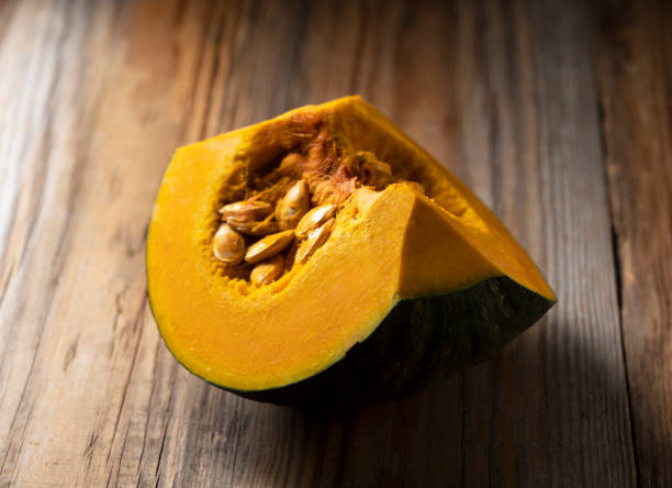 istock Quartered pumpkin on a wooden background 1290615987