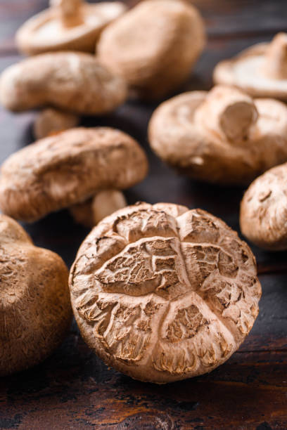 istock Shiitake mushrooms set on old wooden table, side view selective focus 1290619470