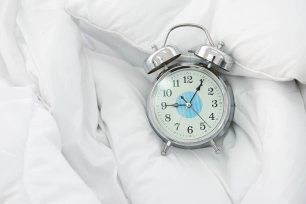 istock Clock at 9 AM on the bed close up 1290623736