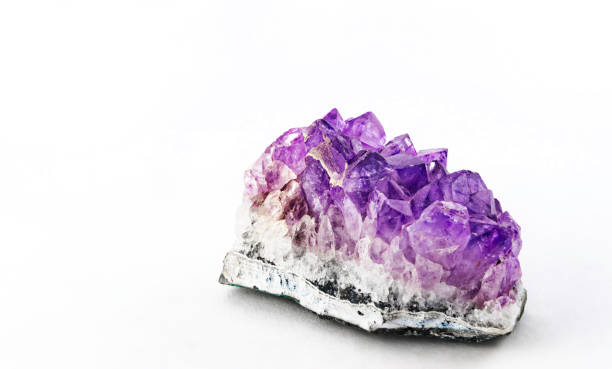 This is a photo of a purple amethyst crystal cluster on a white background.