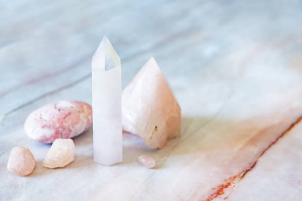 Rose and Angle Aura Quartz Crystals with Rhodonite Palm Stone This is a photo of a variety of crystals including an angel aura quartz tower, rose quartz, and a rhodonite palm stone. crystal photos stock pictures, royalty-free photos & images