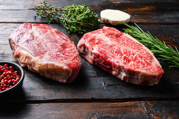 istock Top blade  cut Steak or Feather steak raw meat over old wood table background. Side view 1290625677