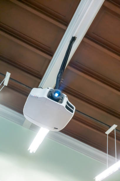 деревянный потолок висит белый проектор с металлической трубкой на белом фоне - projection equipment ceiling mounted mountain стоковые фото и изображения