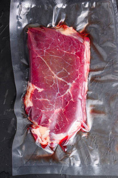 istock Rump beef steak for sous vide cooking on black stone background, top view. 1290626556