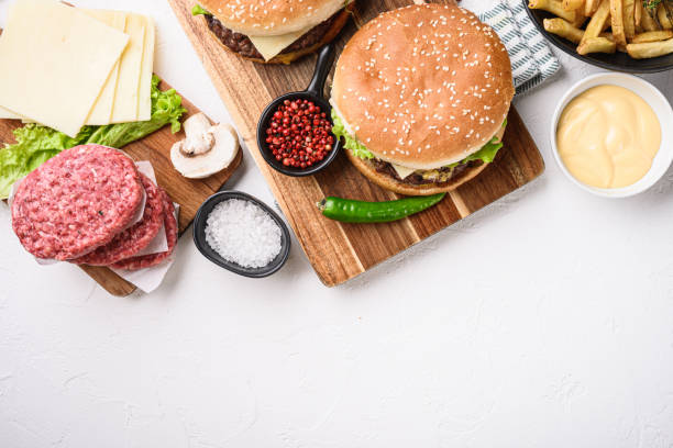 istock Burger with ingredients on white textured background with space for text 1290630100