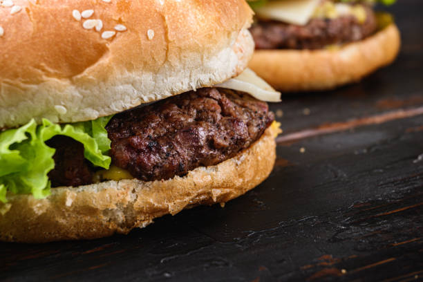 istock Fresh tasty burger on wooden table 1290630273