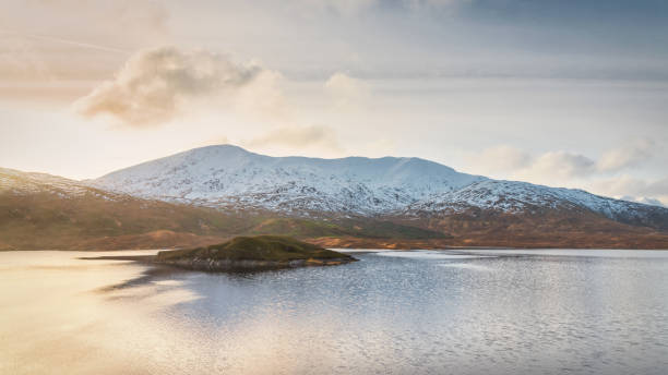 Loch Cluanie Scottish Highlands Winter Sunset Panorama Scotland UK Loch Cluanie Scottish Highlands Winter Sunset Panorama. Snowcapped Scottland Mountains under beautiful sunny cloudscape. Winter Landscape Panorama Northwest Highlands Loch Cluanie, Fort Augustus, Scotland, United Kingdom, Europe. fort augustus stock pictures, royalty-free photos & images