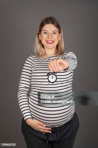 Pregnant Woman Holding A Clock Stock Photo - Download Image Now - Abdomen, Active Lifestyle, Adult