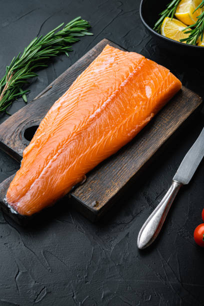 istock Whole raw salmon fillet on black background 1290638318