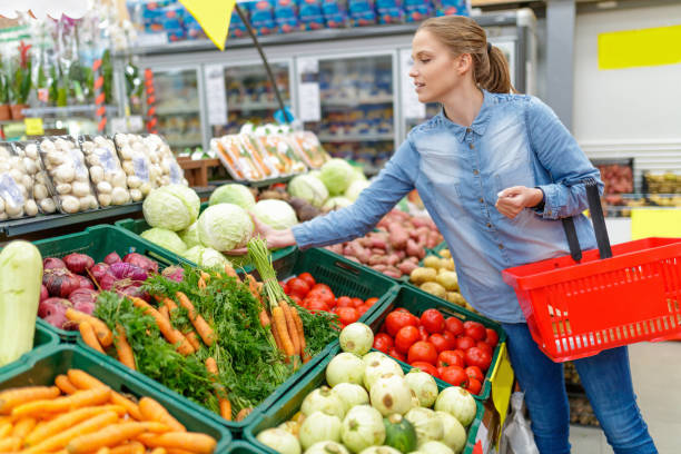 istock Young woman taking cabbage from crate in supermarket 1290641130