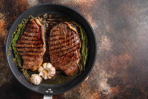 grilled picanha organic  beef steaks on pan with herbs and garlic. over old dark metall background, top view with space for text. - meat steak filet mignon sirloin steak imagens e fotografias de stock