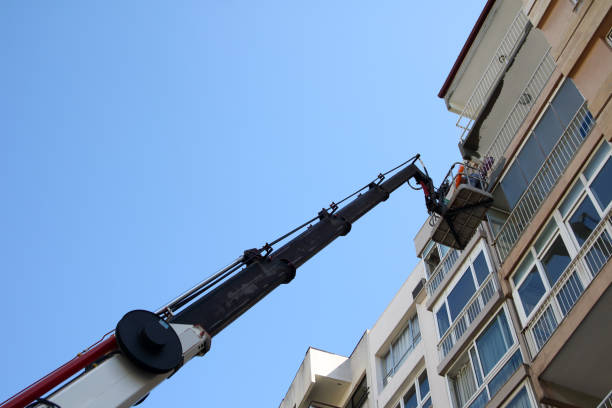 A crane hook suspended in mid-air at a construction site, set against a backdrop of cloudy skies, showcasing the industrial environment.