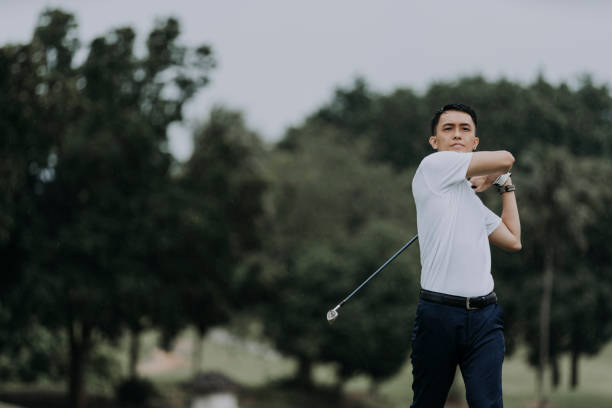 istock asian chinese mature man golfer teeing off at golf course 1290647111