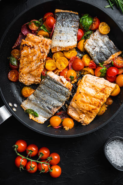 istock Smoky chorizosalmon grilled with cherry tomatoes on black background, top view 1290647461