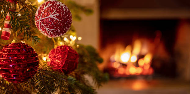 istock Christmas tree close up on blurred burning fireplace background 1290648258