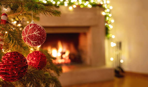 istock Christmas tree close up on blurred burning fireplace background 1290648265